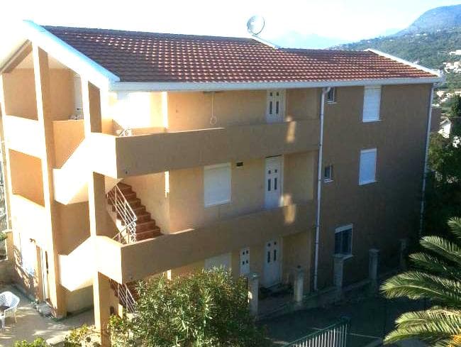 Трехэтажный жилой дом с черепичной крышей и открытыми террасами в поселке Добре-Воде, Черногория.