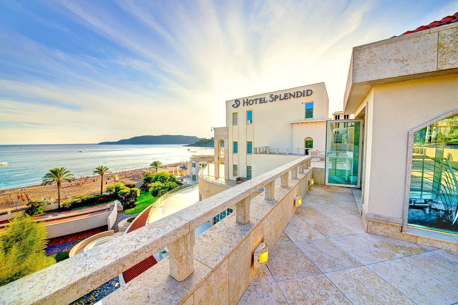 Вид с террасы отеля Splendid на море и пляж в Бечичи, Черногория: каменная отделка, панорамный морской пейзаж.