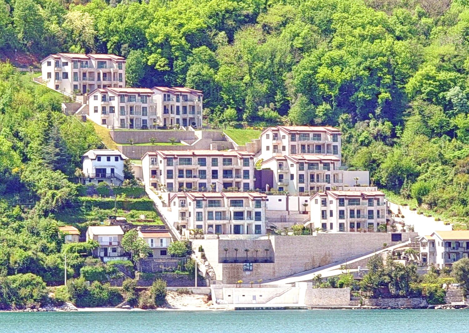 Жилой комплекс в Морини, Черногория: современные апартаменты на склоне горы с видом на море и зеленый лесной массив.