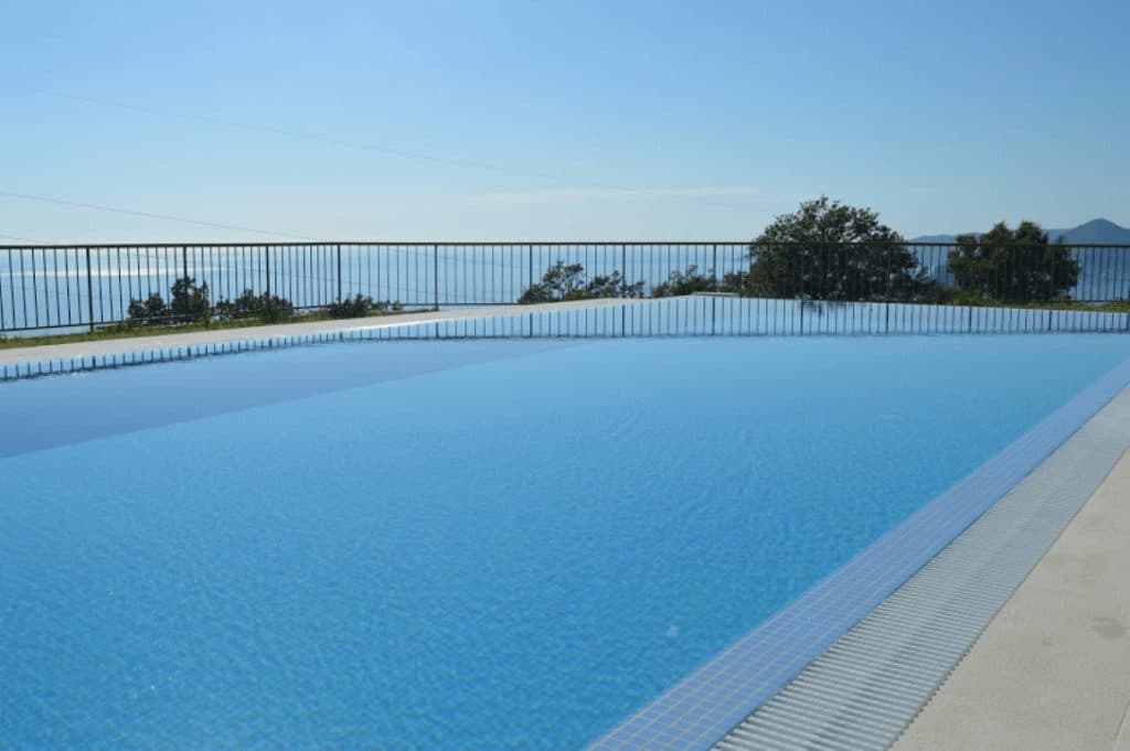 Открытый инфинити-бассейн на вилле в Близикуче, Черногория, с панорамным видом на Адриатическое море и горы.