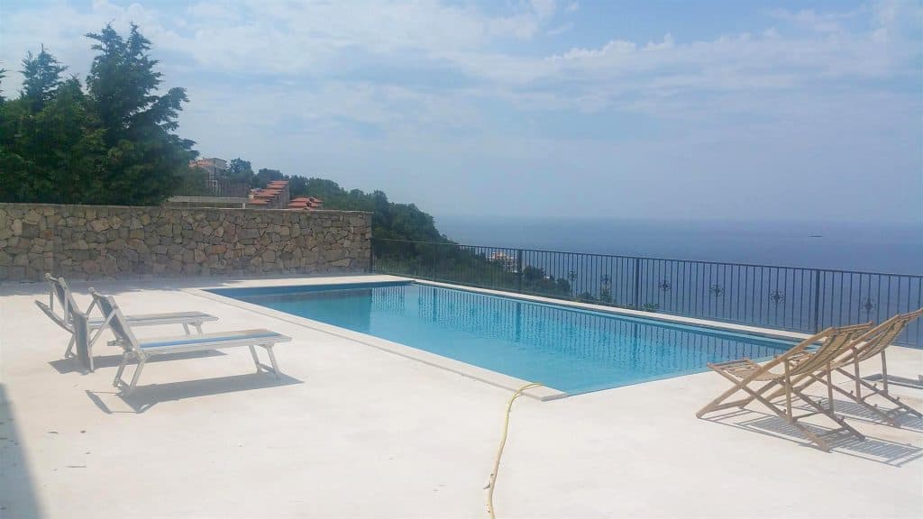 Открытый бассейн на вилле в Дробны песак, Черногория: терраса с шезлонгами и панорамным видом на Адриатическое море.