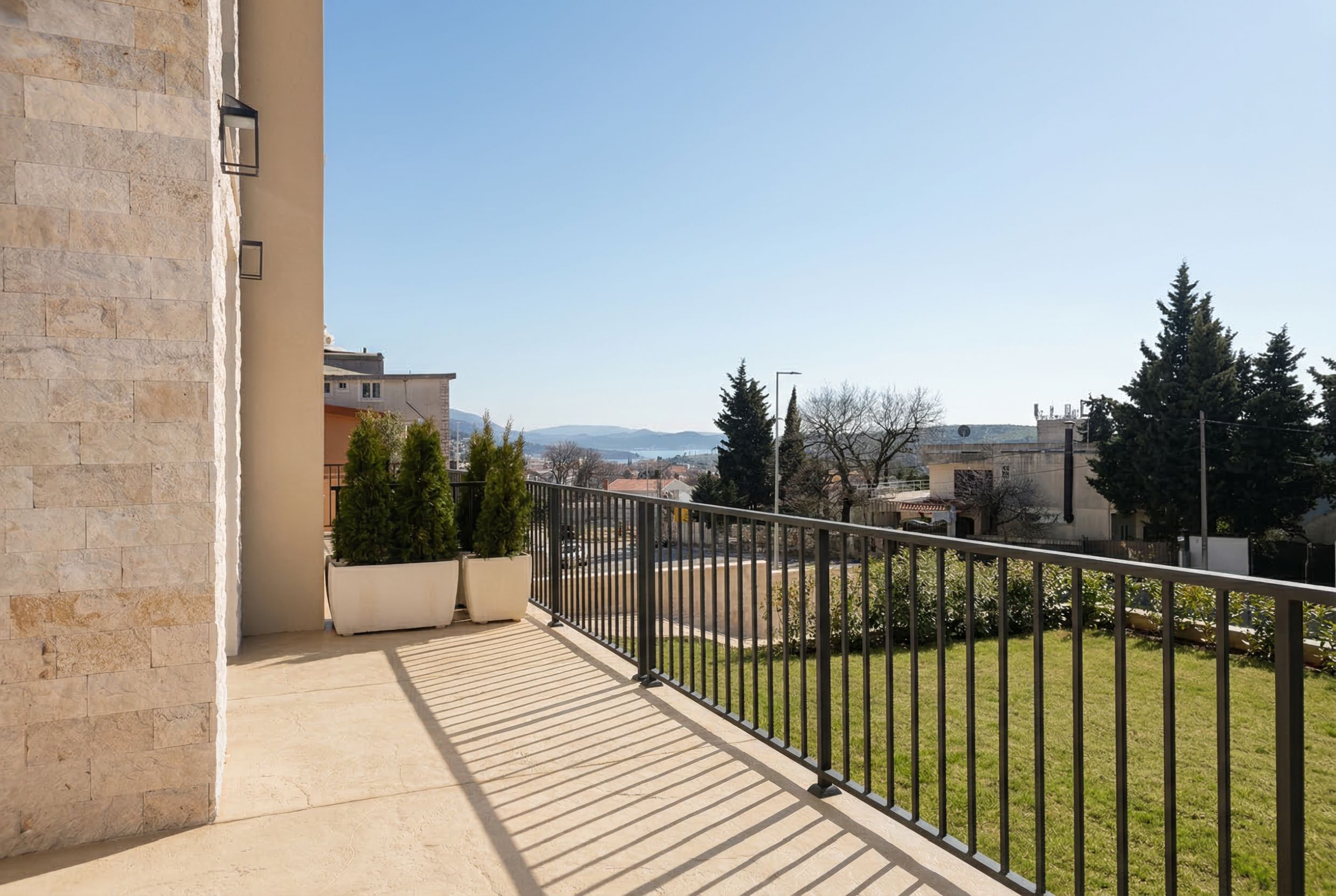 Spacious balcony with stone finishes and views of the mountains and sea in an apartment, Sutomore, Montenegro.