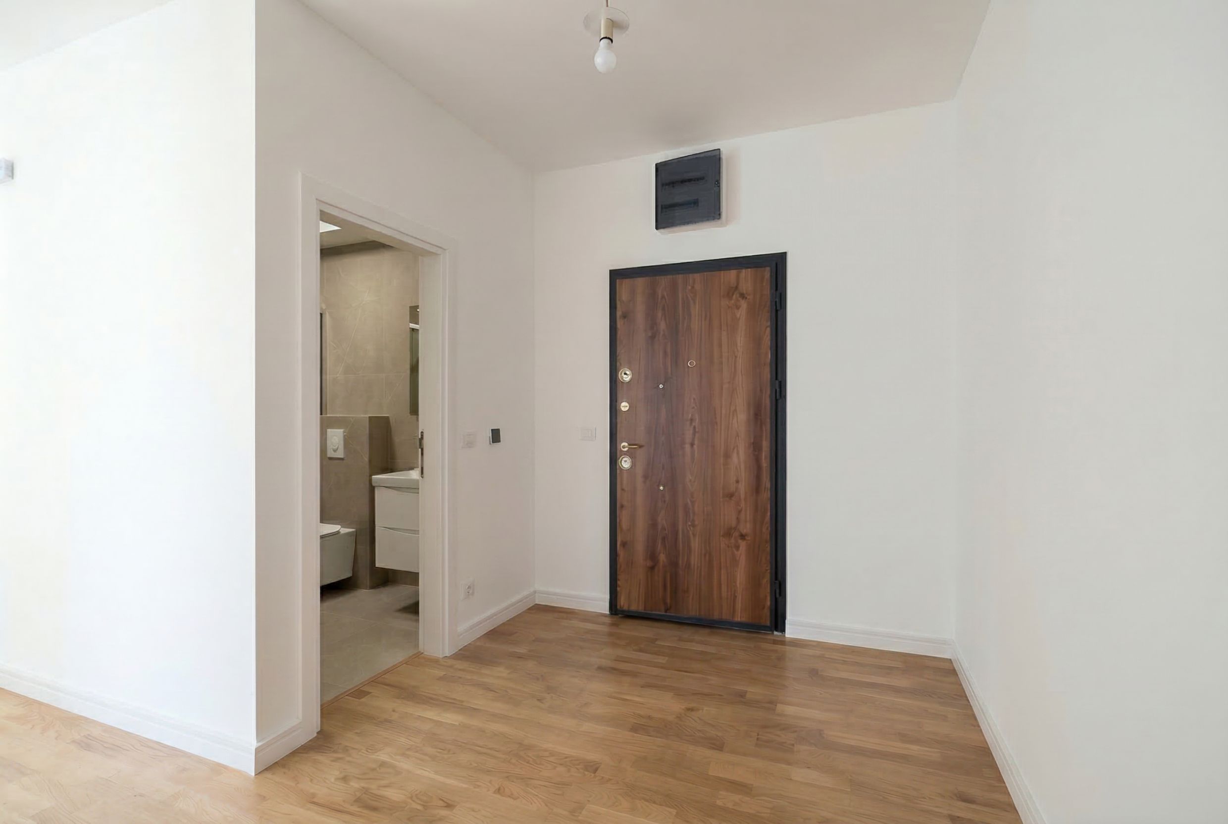 Hallway with a wooden door and entrance to the bathroom in a new apartment, Sutomore, Montenegro.