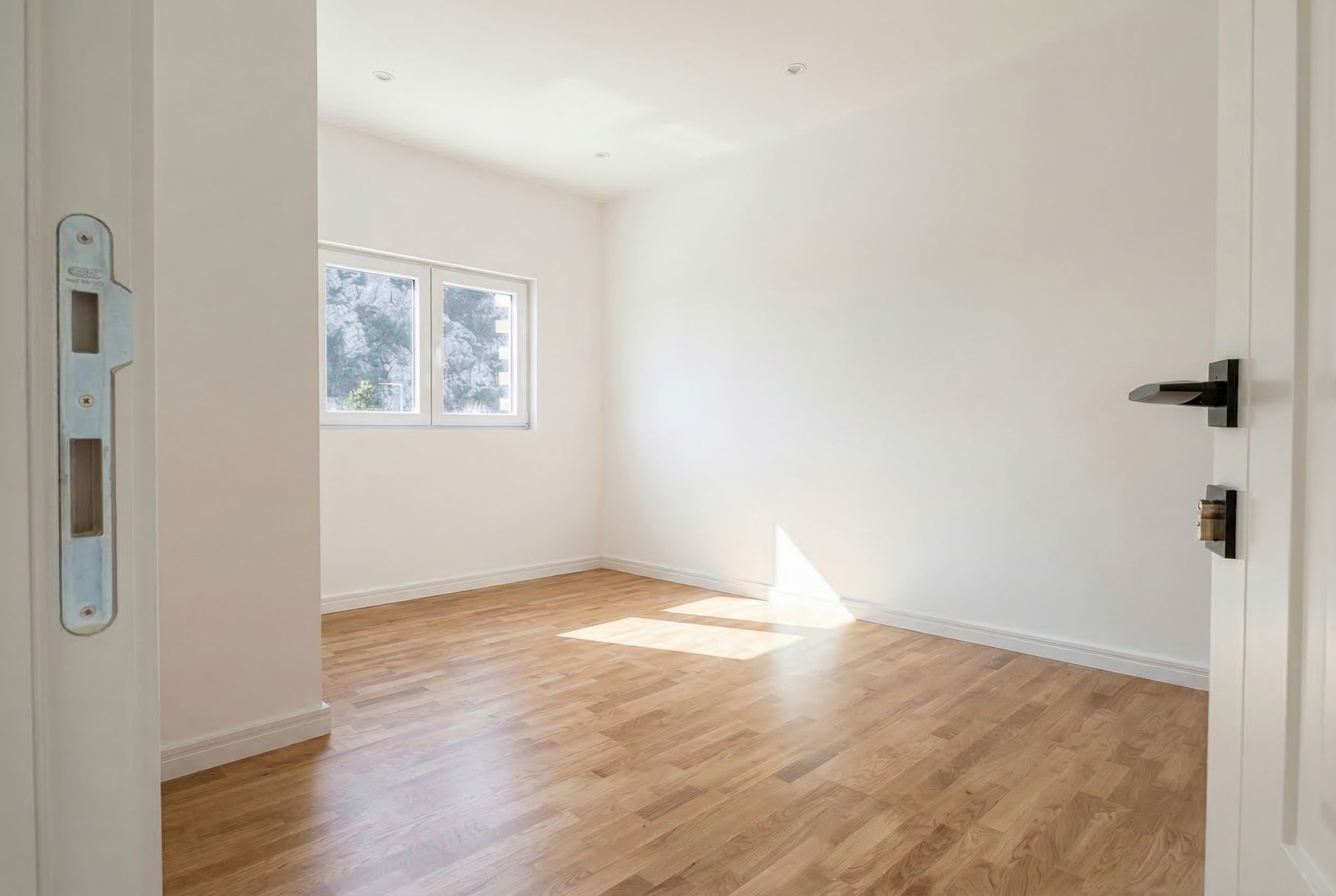 Bright empty bedroom with parquet flooring and mountain views in an apartment for sale, Sutomore, Montenegro.