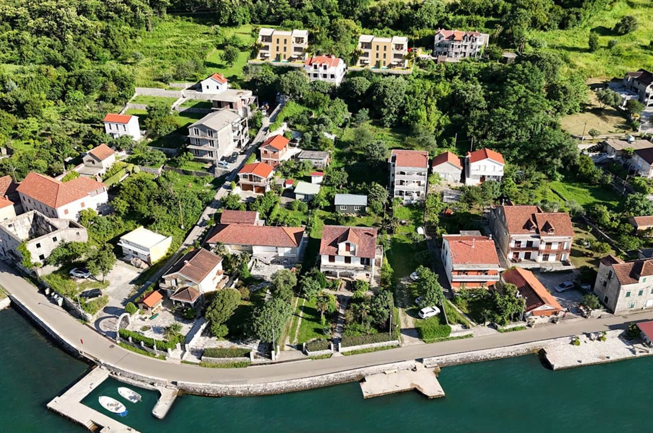 Aerial view of coastal houses and green area in the village of Stoliv, Montenegro.