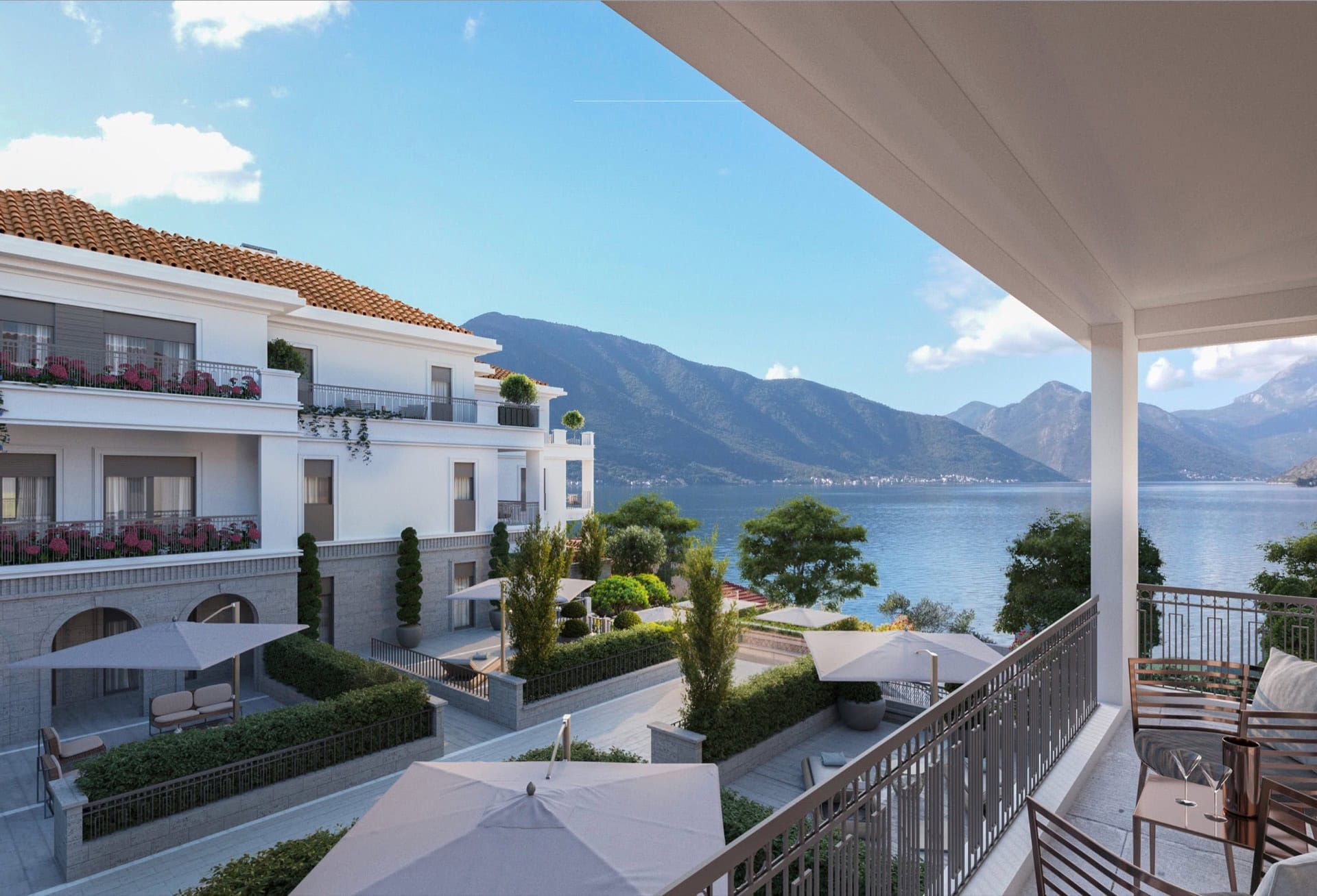 View from the balcony of a residential complex in Ljuta, Montenegro: terraces with furniture, landscaping, and a panoramic view of the Bay of Kotor.