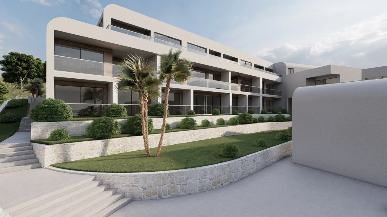 Exterior of a modern multi-story building with balconies, palm trees, and stone retaining walls.