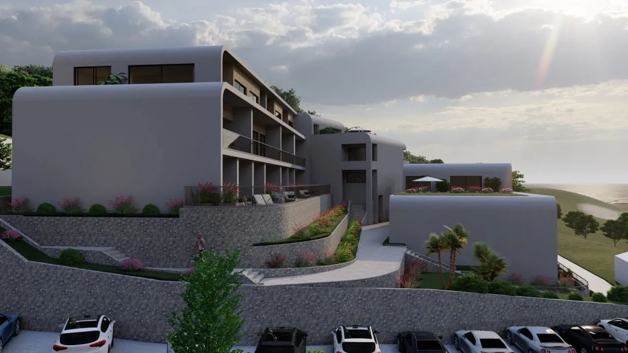 Modern multi-level building with terraces, gardens, and parking near the sea.