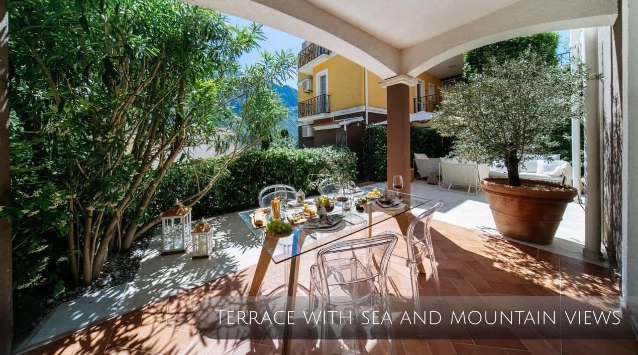 Cozy terrace with a dining area and mountain views in an apartment, Orahovac, Montenegro. Glass table and transparent chairs.