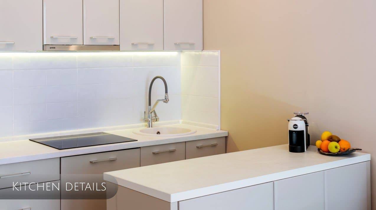 Modern kitchen in an apartment in Orahovac, Montenegro: white fronts, built-in appliances, and stylish lighting.