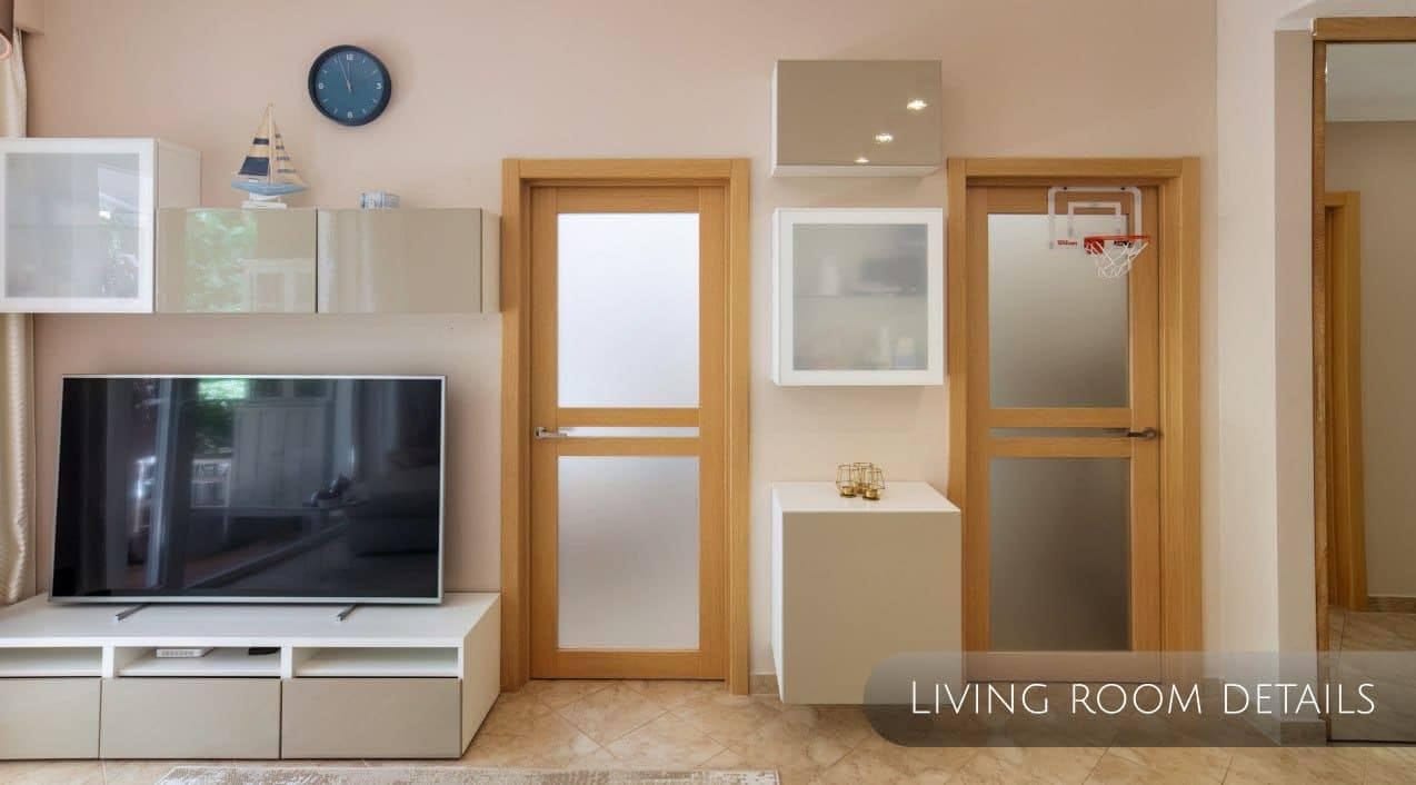Modern living room in an apartment in Orahovac, Montenegro: TV area, light-colored furniture, and interior doors with glass.