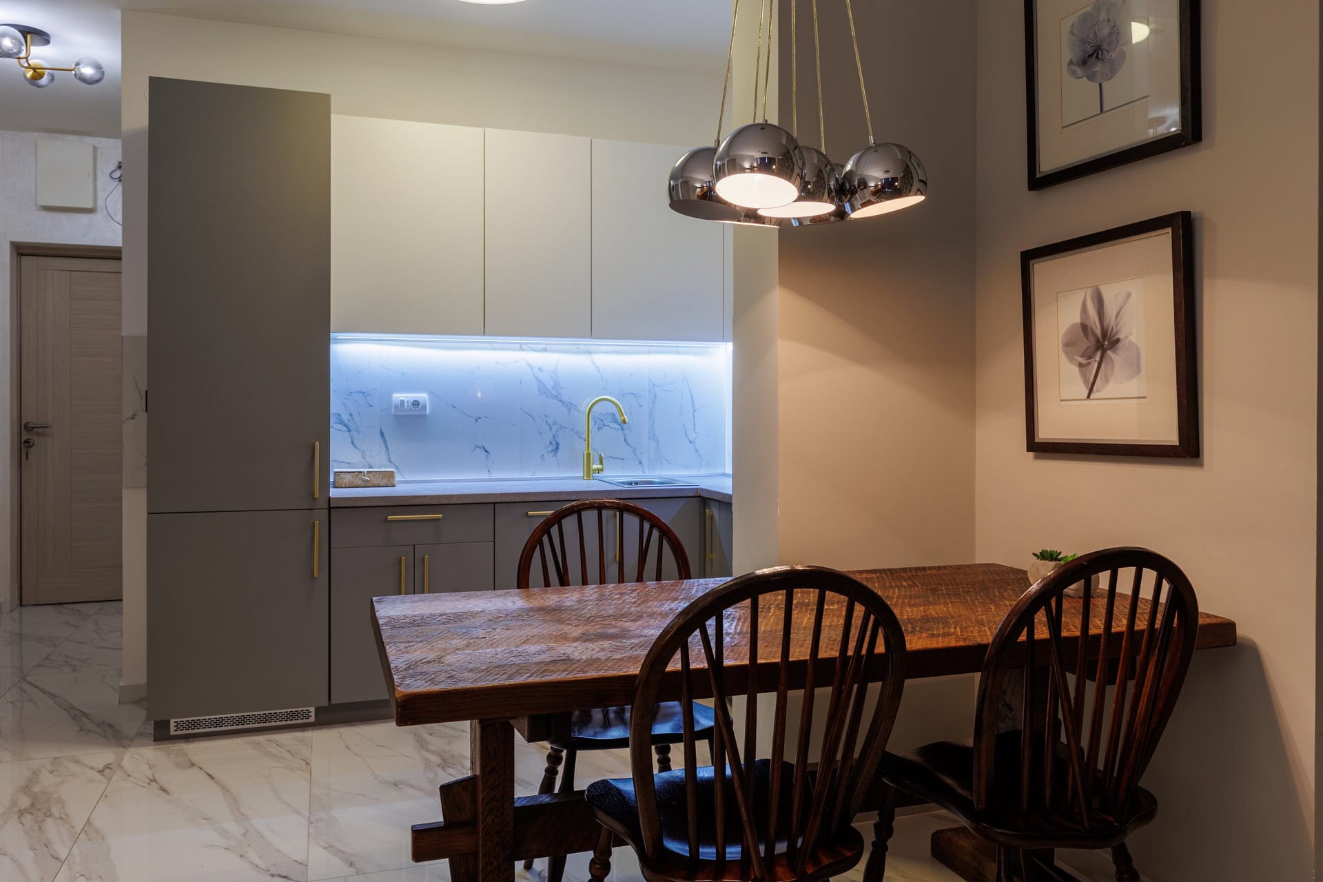 Modern kitchen in an apartment in Bečići, Montenegro: dining area with a wooden table and a stylish kitchen set.