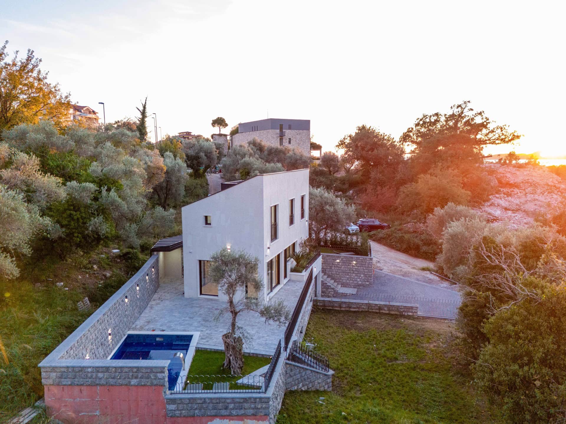 Modern villa with a pool and terrace surrounded by olive trees, Kamenovo, Montenegro. Aerial view.