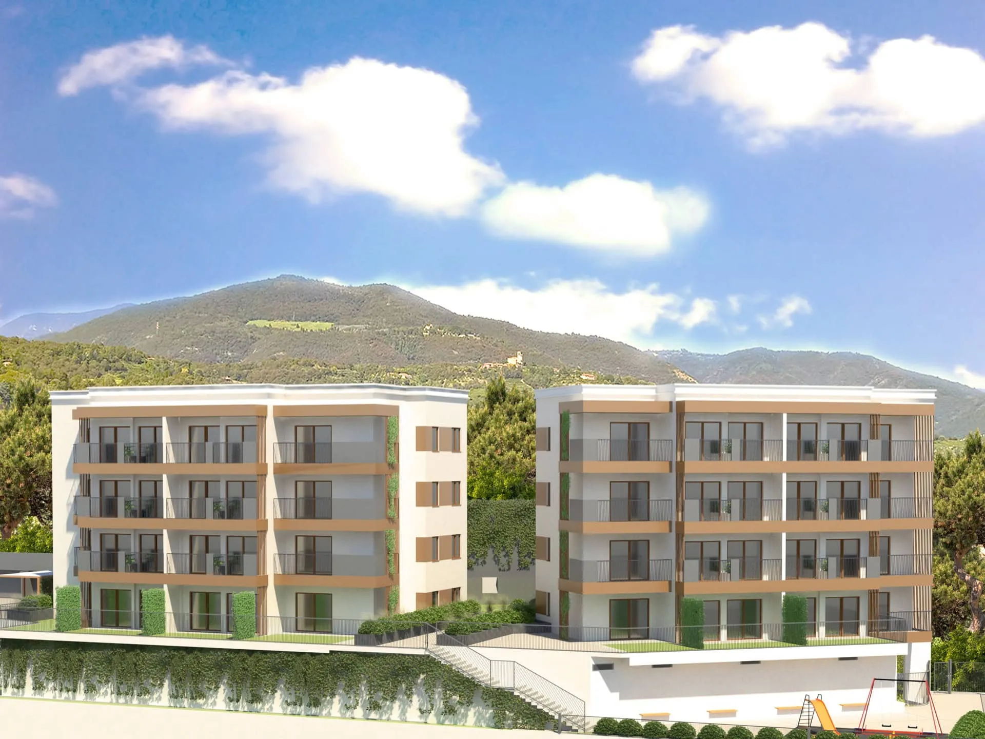 Modern residential complex of two buildings with balconies set against a backdrop of green mountains and blue sky with white clouds.