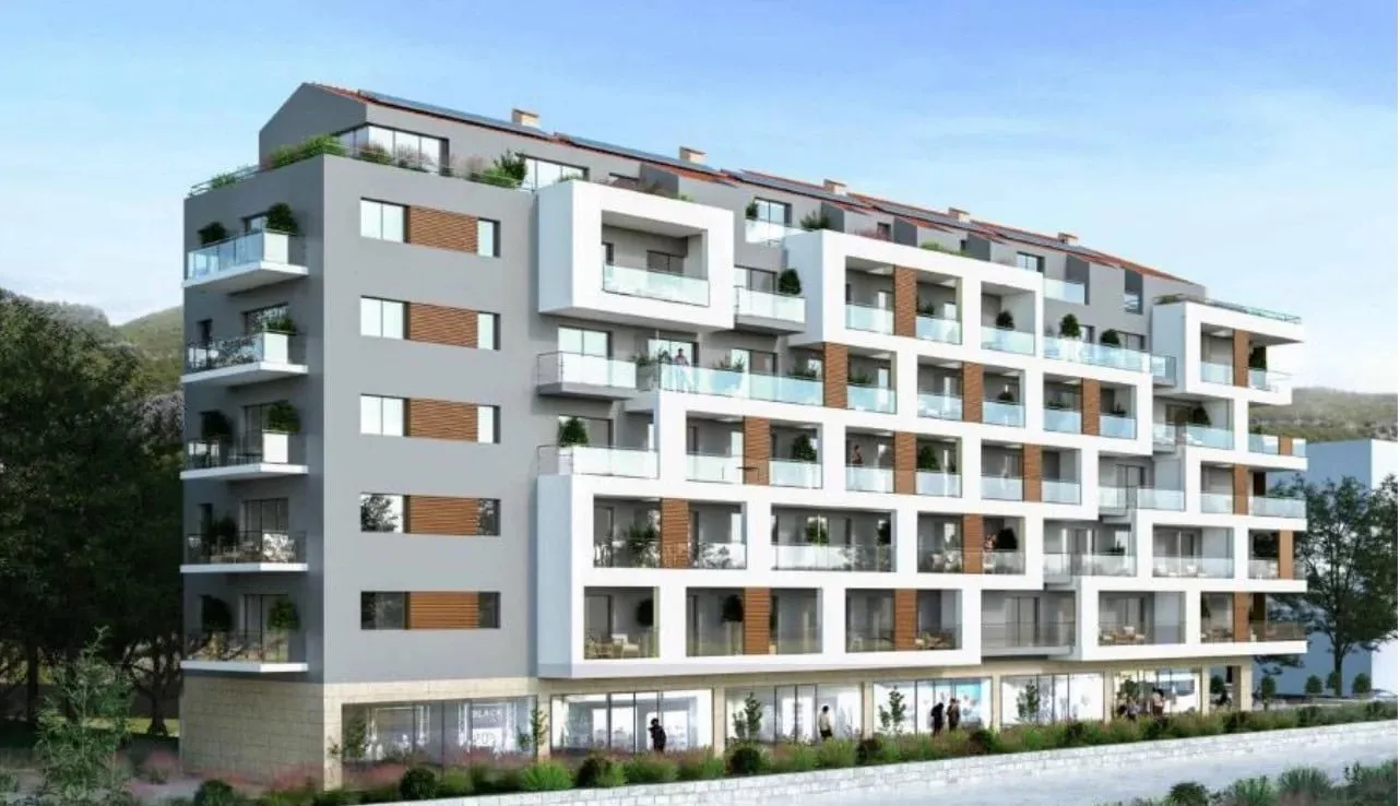 Modern multi-story residential building with balconies, wood paneling, and glass railings.