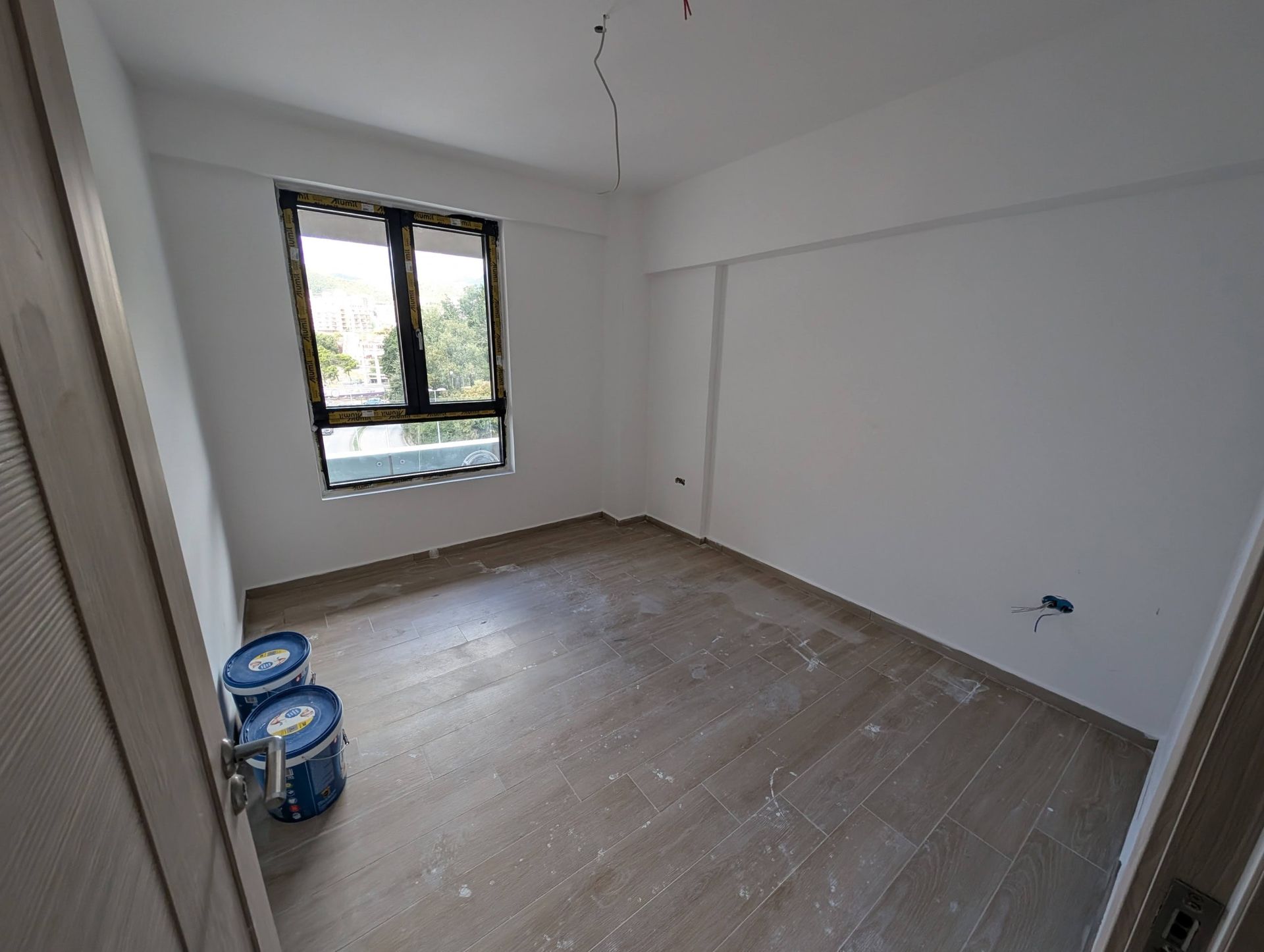 Bedroom with finished finishes, white walls, and wood-look tile in a new construction apartment, Rafailovići, Montenegro