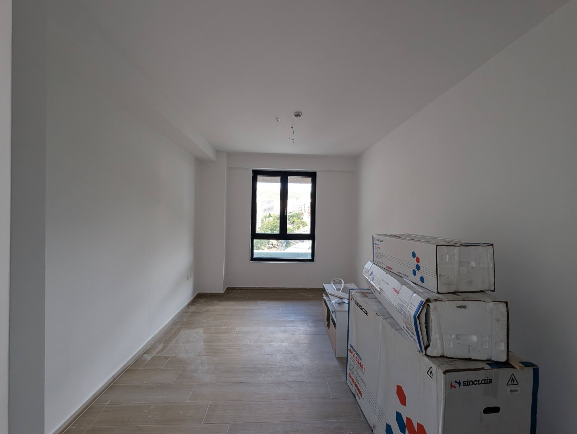 Living room with finished finishes and boxes of materials in a new construction apartment in Rafailovici, Montenegro.