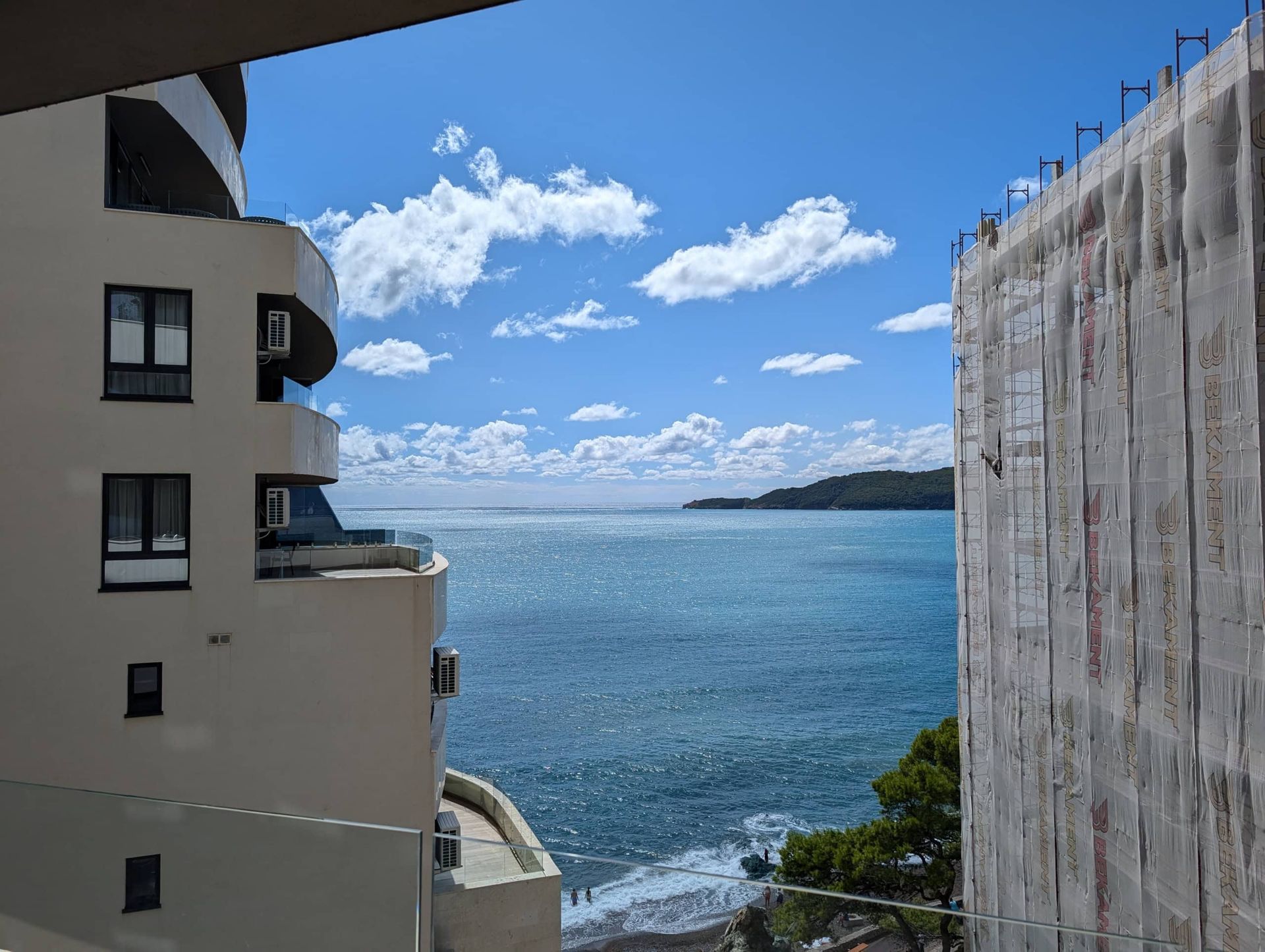 Sea view from the apartment balcony in Rafailovići, Montenegro, between residential buildings