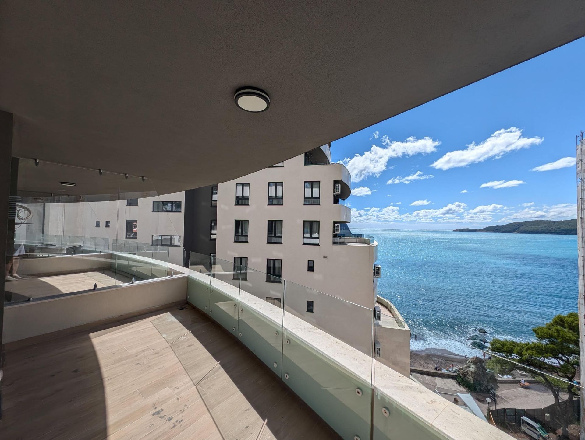Spacious balcony with panoramic glazing and sea view in a residential complex in Rafailovici, Montenegro