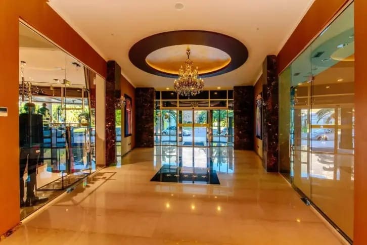 Luxurious hotel lobby in Budva, Montenegro: marble floor, crystal chandelier, panoramic windows, and stylish interior.