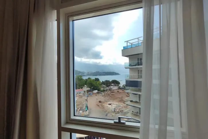 View from the bedroom window of the sea and city in an apartment in Budva, Montenegro: modern apartments with panoramic glazing.