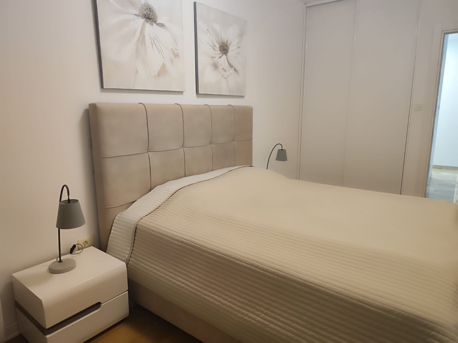 Cozy bedroom with a double bed in an apartment in Budva, Montenegro: modern furniture, bright interior, and decor.