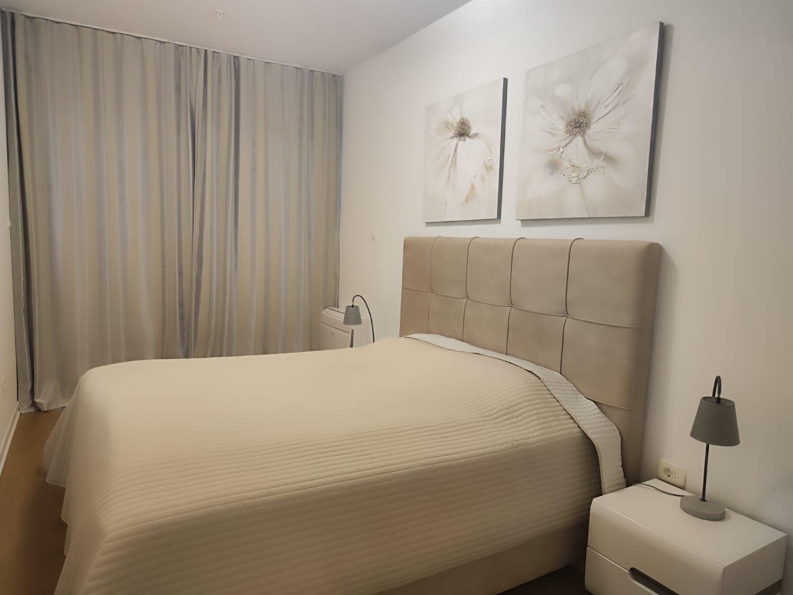 Cozy bedroom with a double bed in a modern apartment in Budva, Montenegro: bright interior and decor.
