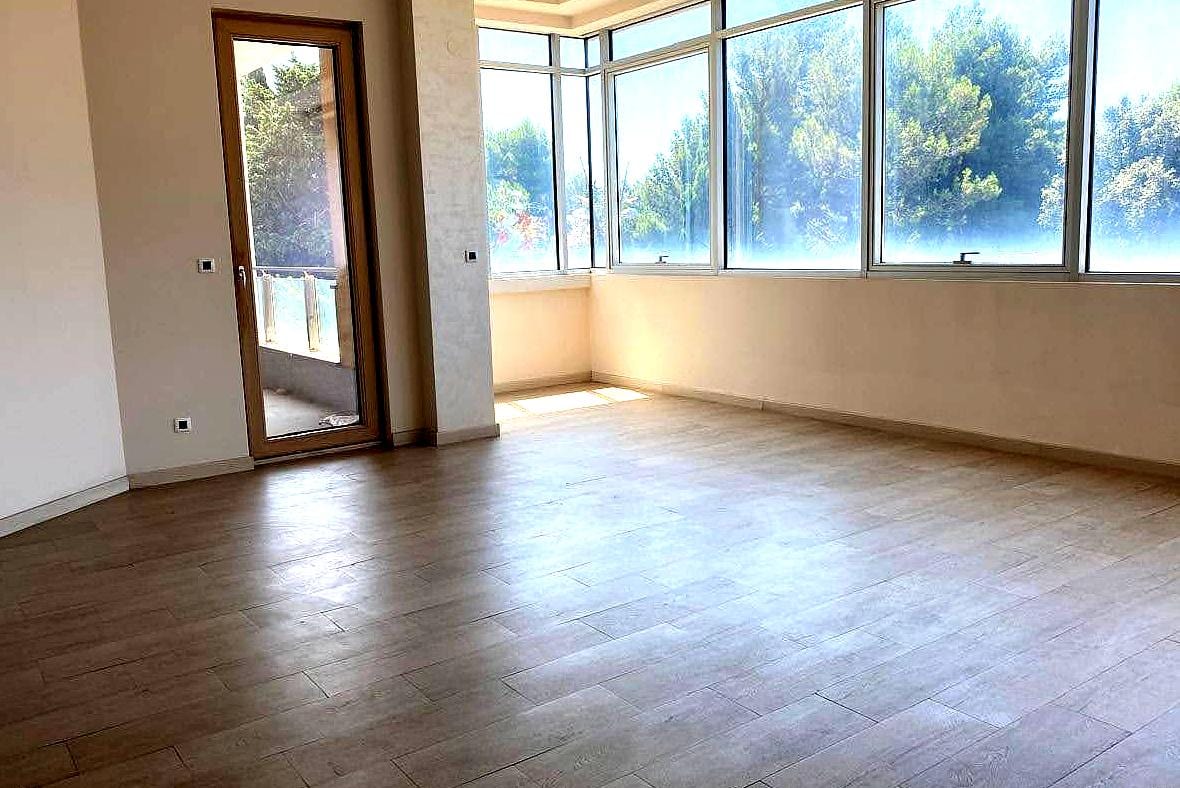 Bright living room with panoramic windows and access to the balcony in an apartment in the center of Budva, Montenegro.