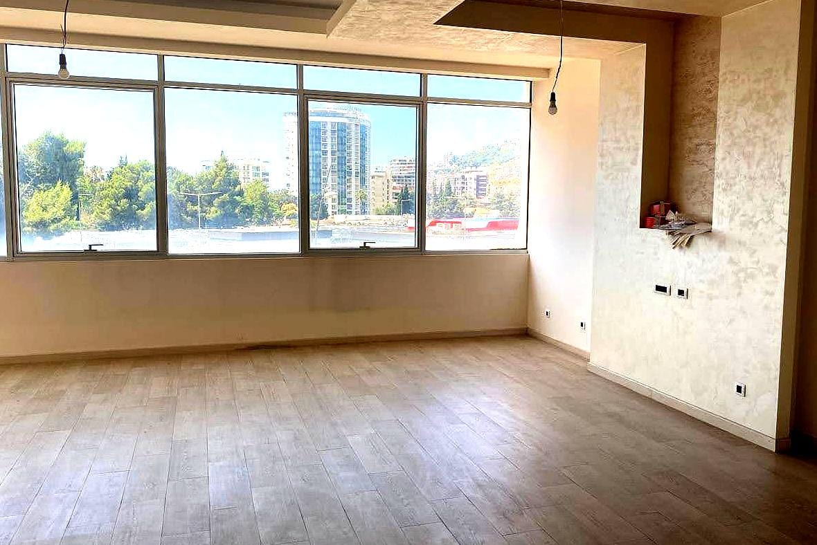 Bright living room with panoramic windows and city views in an apartment in central Budva, Montenegro. Modern finishes.