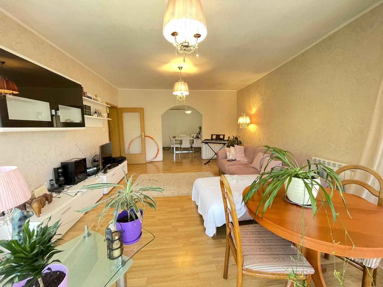 Cozy living room with soft furniture and a dining area in a house, Bar, Montenegro. Bright interior with parquet flooring.
