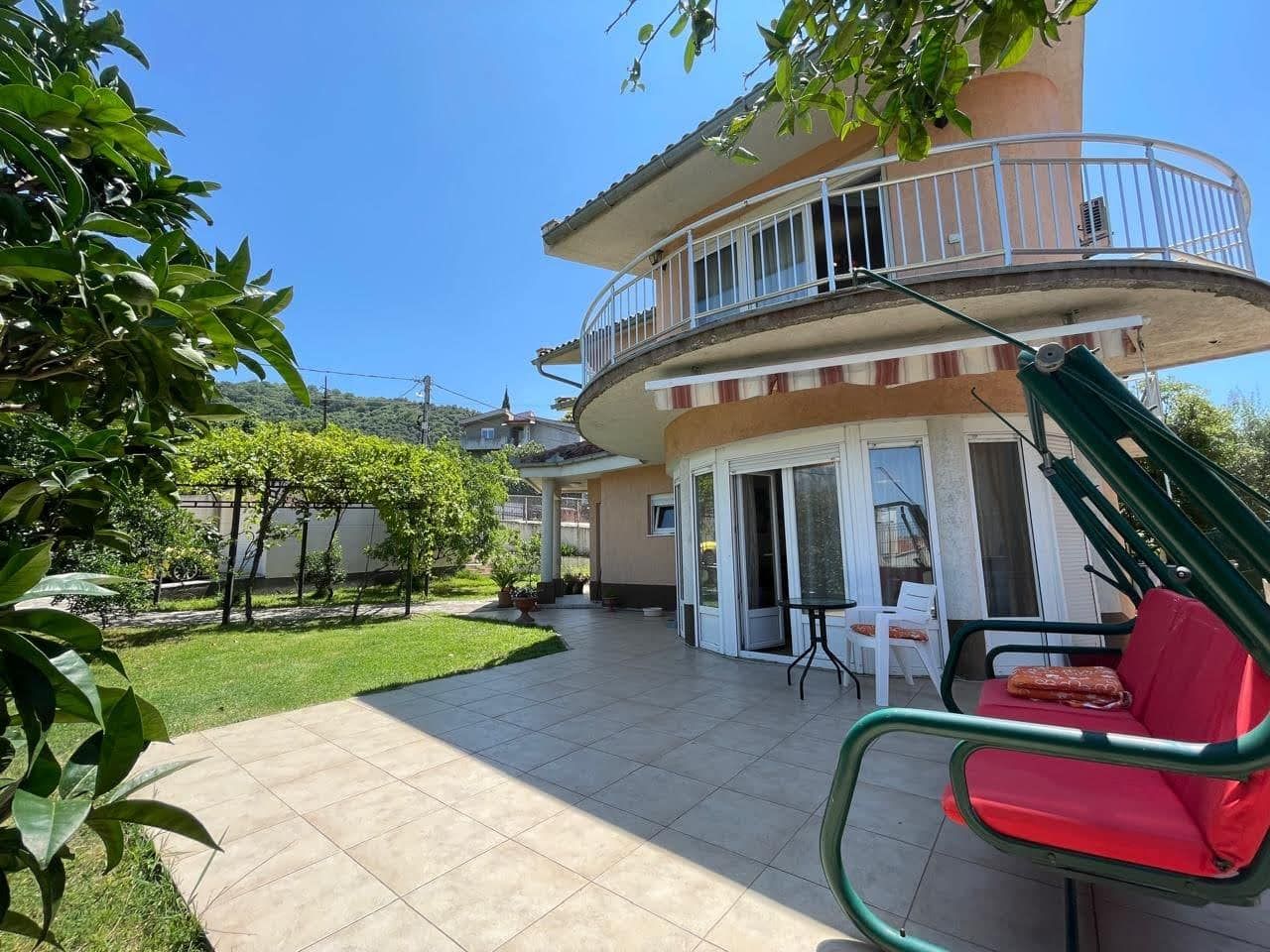 Two-story house with a terrace, garden swing, and green garden in the city of Bar, Montenegro.