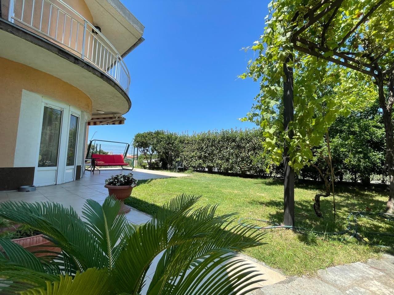Cozy house in Bar, Montenegro: terrace with a swing, green garden with a vineyard and a palm tree on the property.