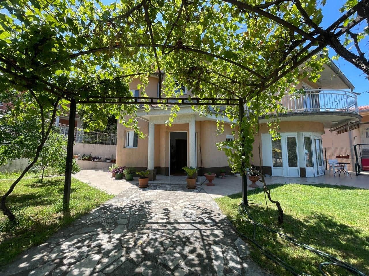Two-story house with a terrace and grape pergola in the garden, real estate for sale in the city of Bar, Montenegro.