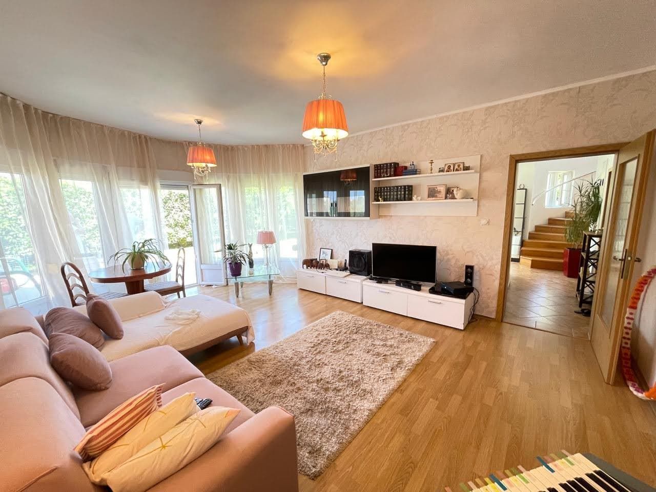 Cozy living room with a soft sofa, panoramic windows, and access to the terrace in a house, city of Bar, Montenegro.