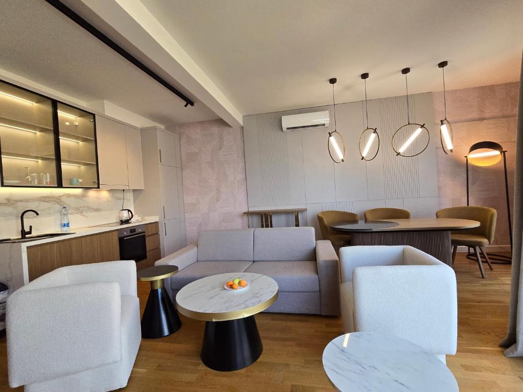 Modern living room with kitchen in an apartment in Bečići, Montenegro: stylish furniture, marble tables, and a cozy interior.