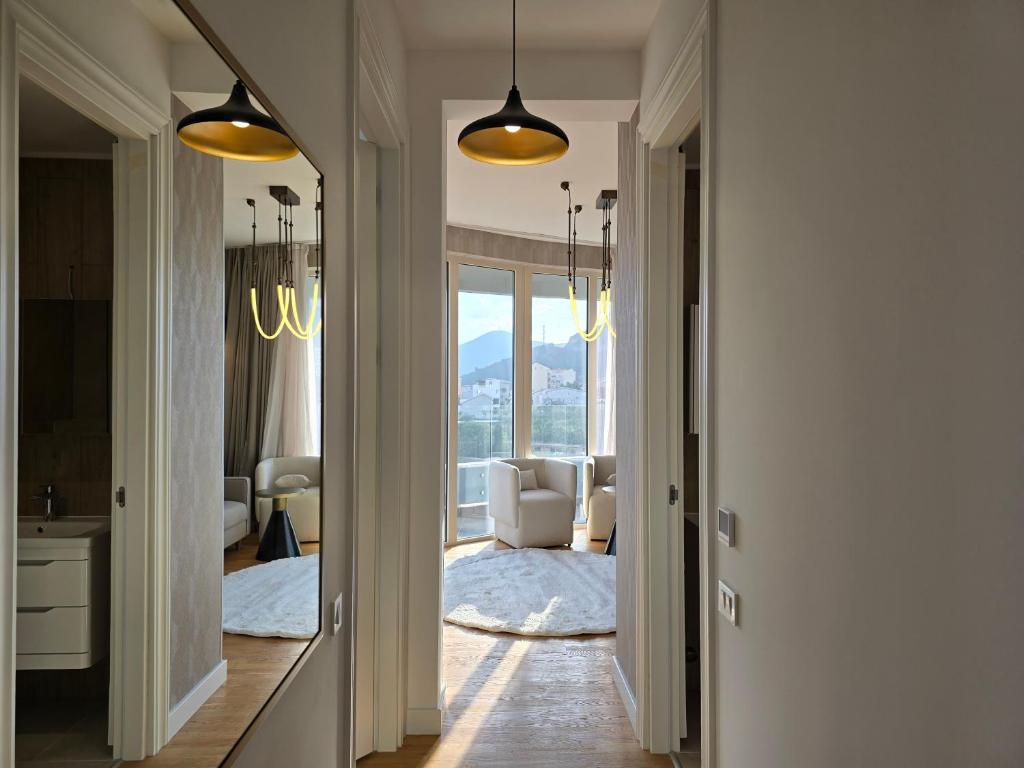Modern hallway and living room in an apartment in Bečići, Montenegro: bright interior, panoramic windows, and mountain views.