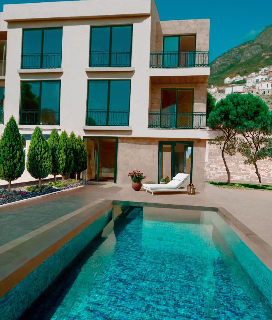 Modern townhouse with a pool and terrace in Blizikuće, Montenegro: view of the facade with panoramic windows and mountains.