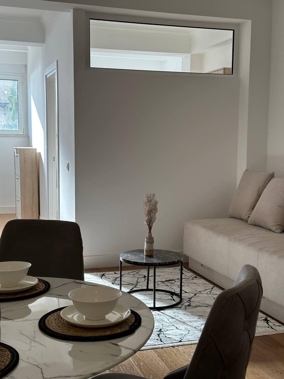 Modern living room with dining area in an apartment, Tivat, Montenegro: marble table, sofa, and stylish interior.