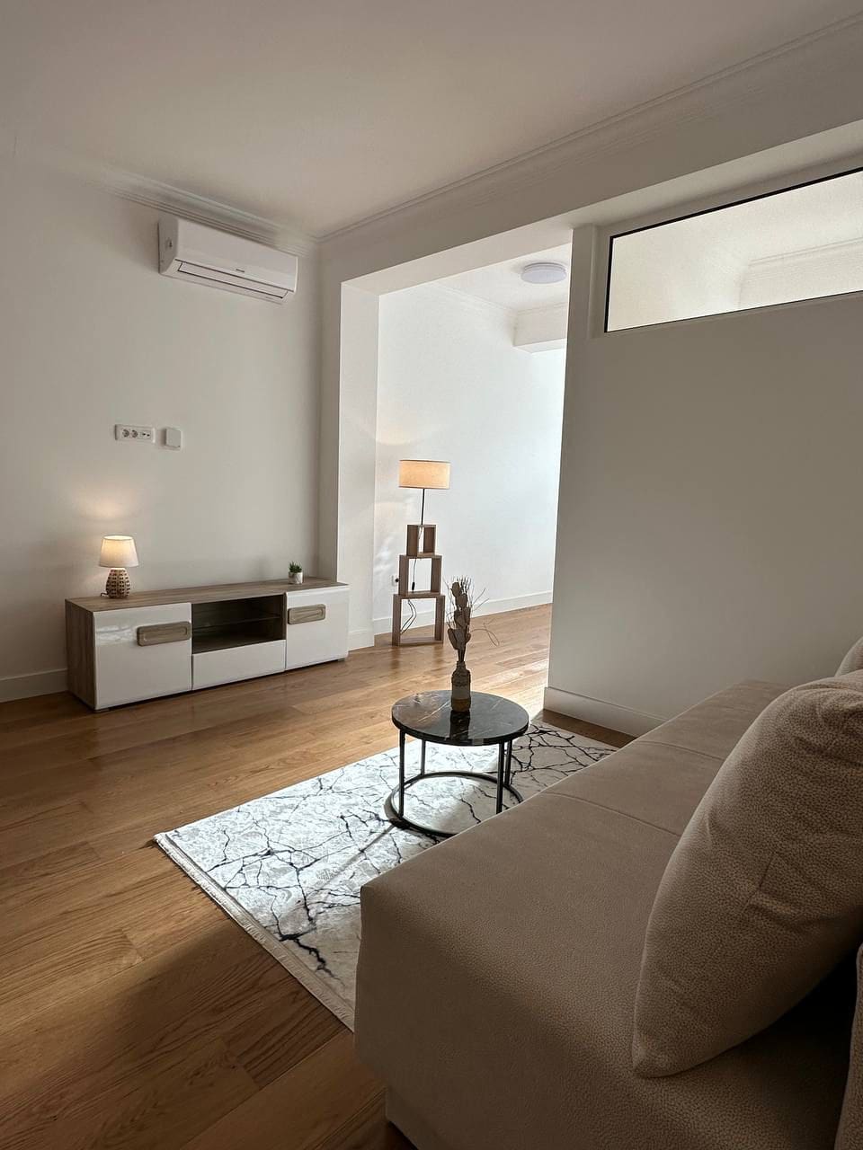 Bright living room in an apartment, Tivat, Montenegro: modern furniture, parquet flooring, air conditioning, and cozy lighting.
