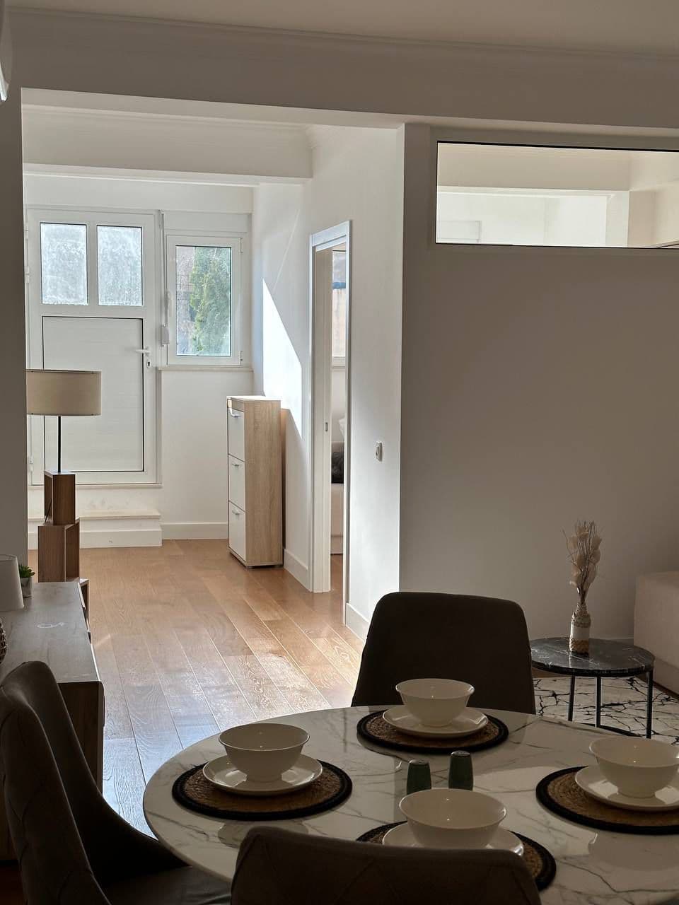 Bright living room with dining area and parquet flooring in an apartment, Tivat, Montenegro. Modern interior with access to the balcony.