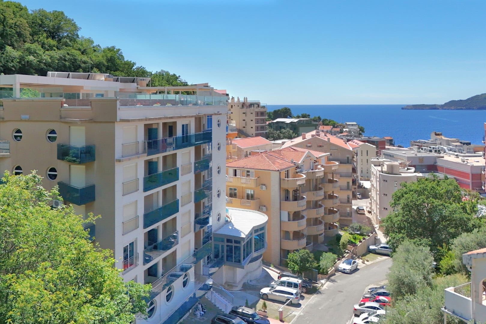 View of a modern house in Reževići, Montenegro: panoramic view of the sea, residential complex, and surrounding area.