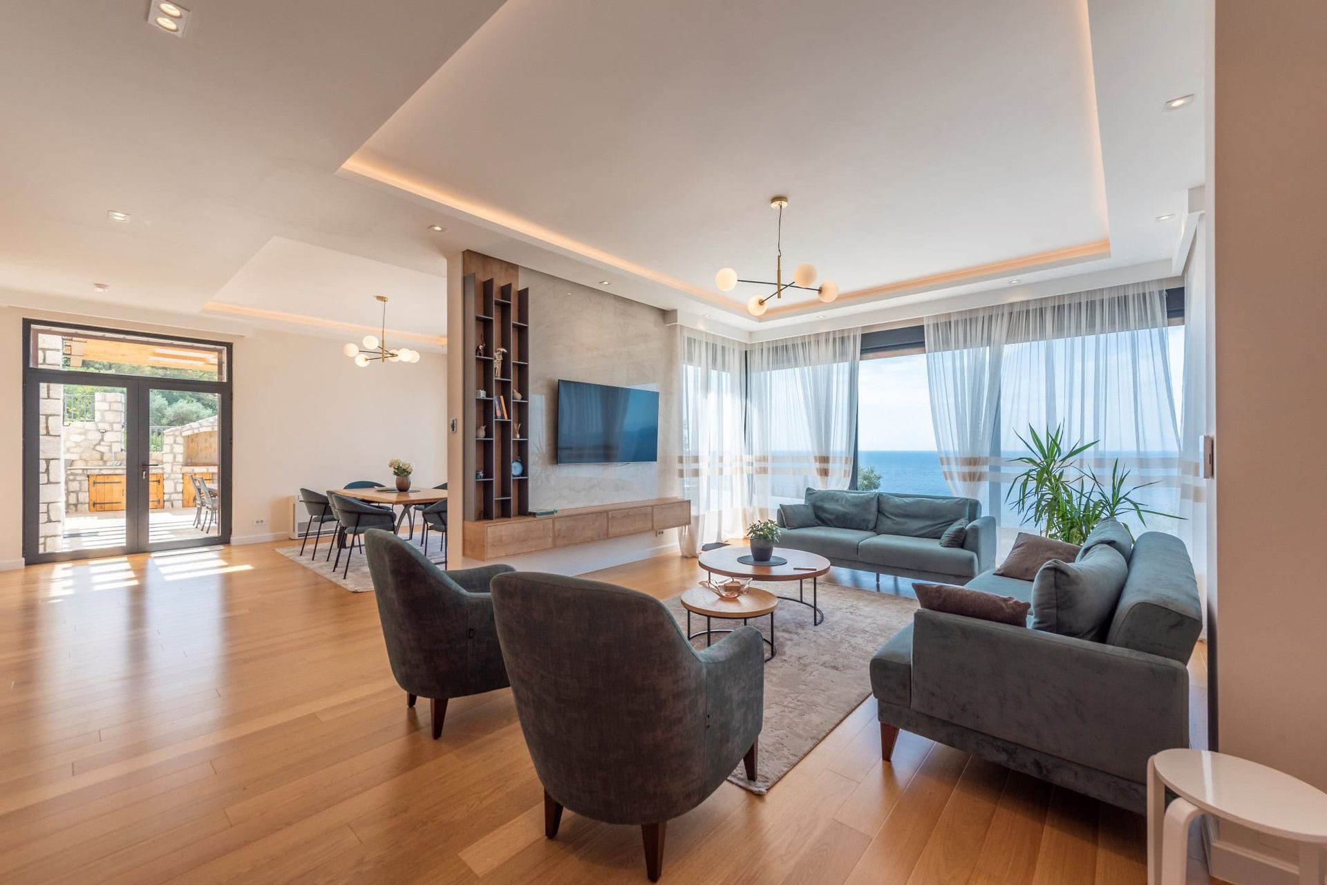 Modern living room with panoramic sea view in a house, Reževići, Montenegro: stylish furniture and terrace.