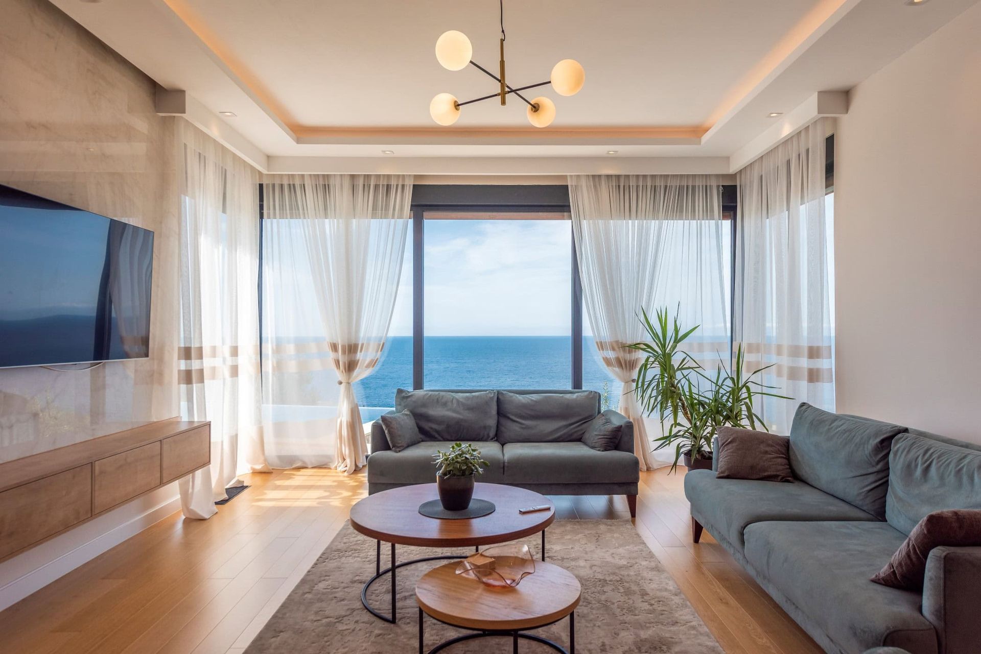 Living room with panoramic sea view in a house, Reževići, Montenegro: modern furniture, bright interior, and a terrace.