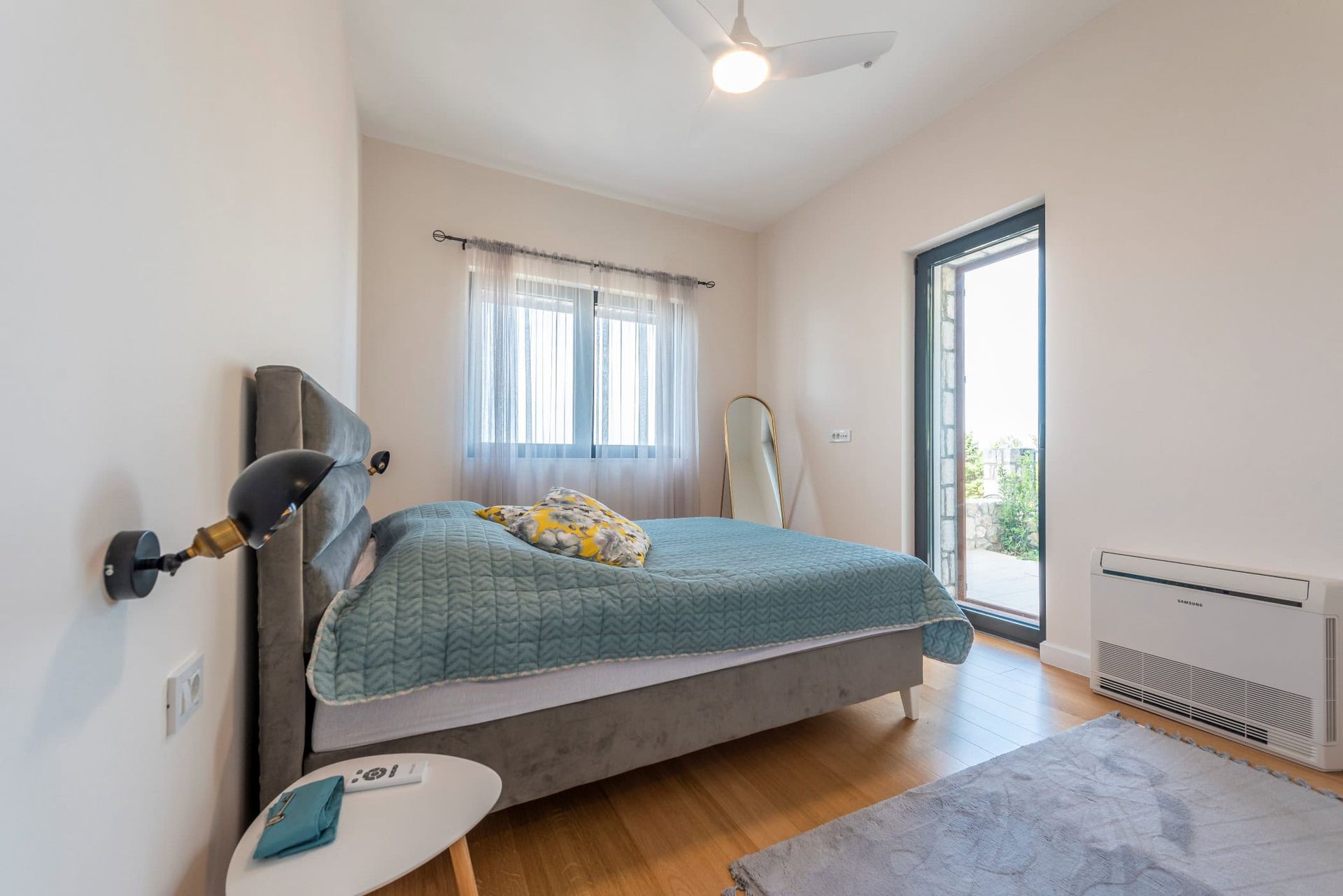 Cozy bedroom with a double bed and access to the terrace in a house, Reževići, Montenegro. Modern interior.