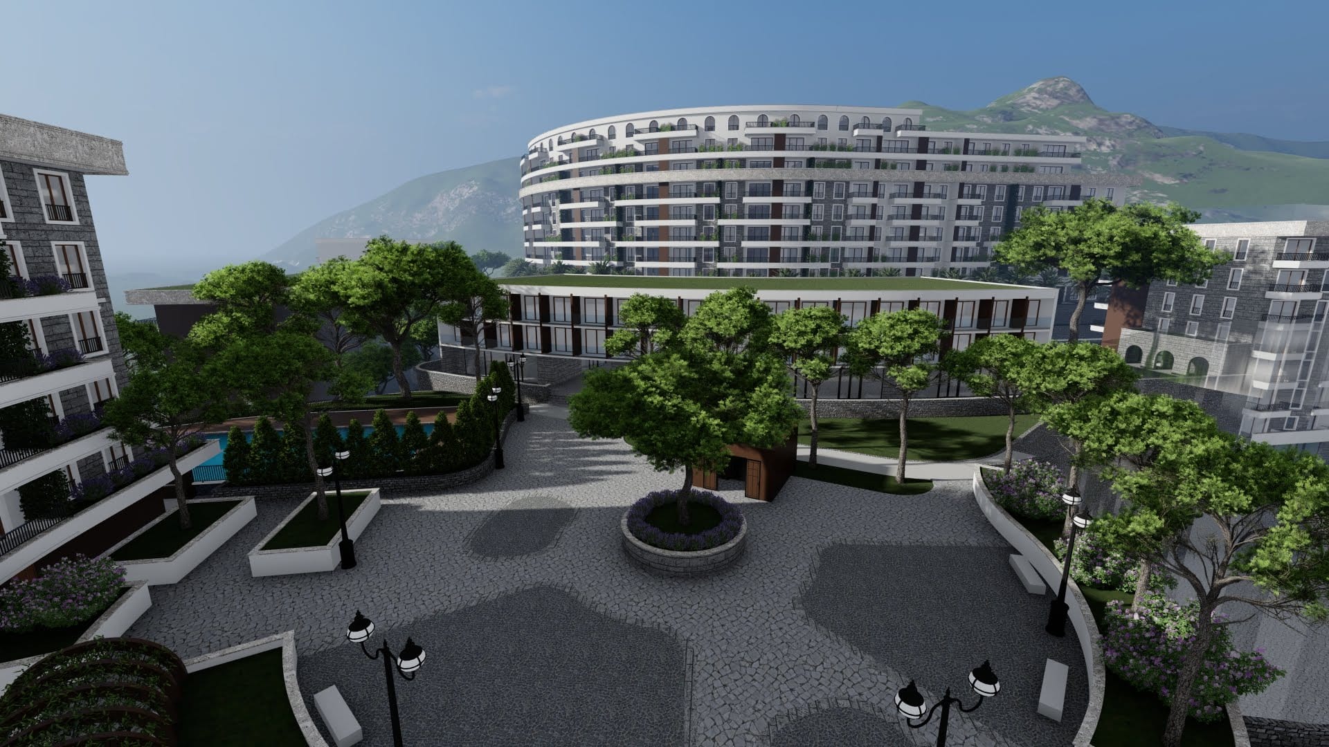 Modern residential complex in Bečići, Montenegro: landscaped grounds with trees, a swimming pool, and mountain views.