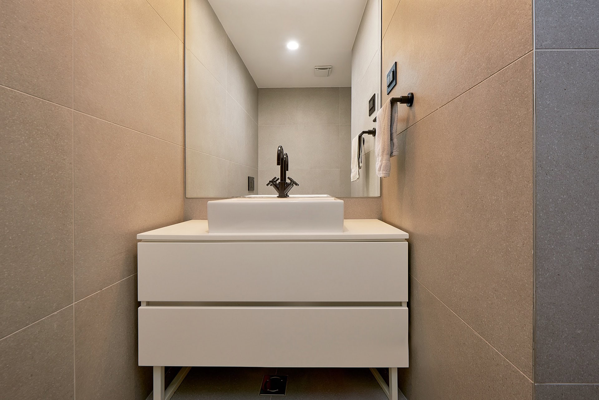 Modern bathroom with a white vanity and vessel sink in an apartment in the center of Budva, Montenegro.