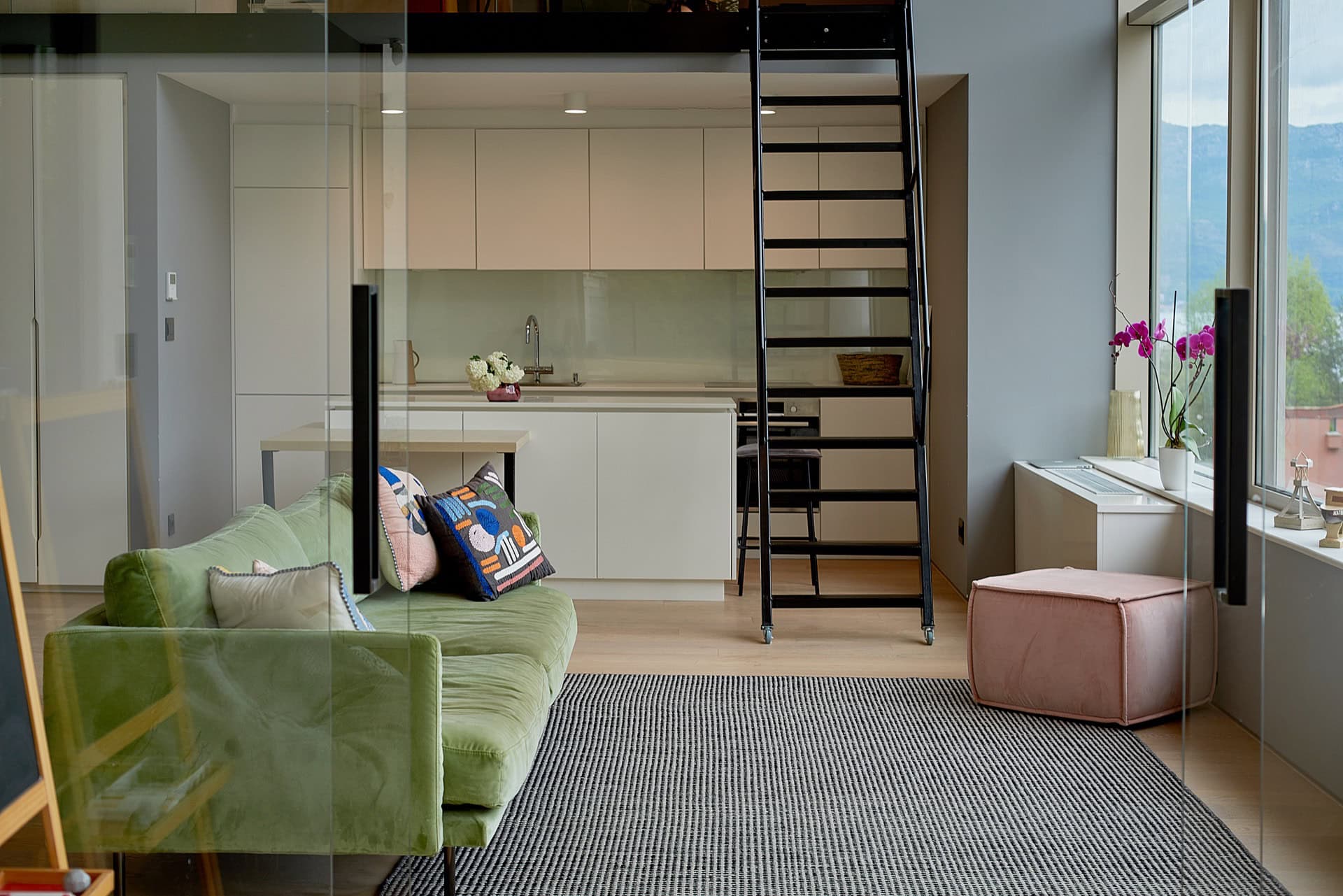 Modern living room with kitchen and staircase to the second level in an apartment in the center of Budva, Montenegro.