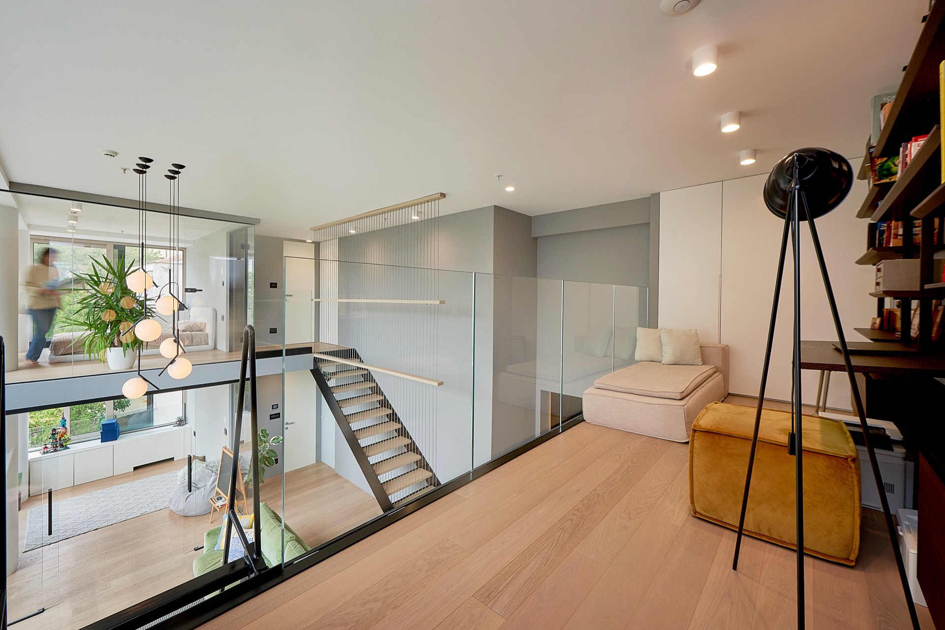 Modern duplex apartment in Budva, Montenegro: living room with glass railings and a loft-style staircase.