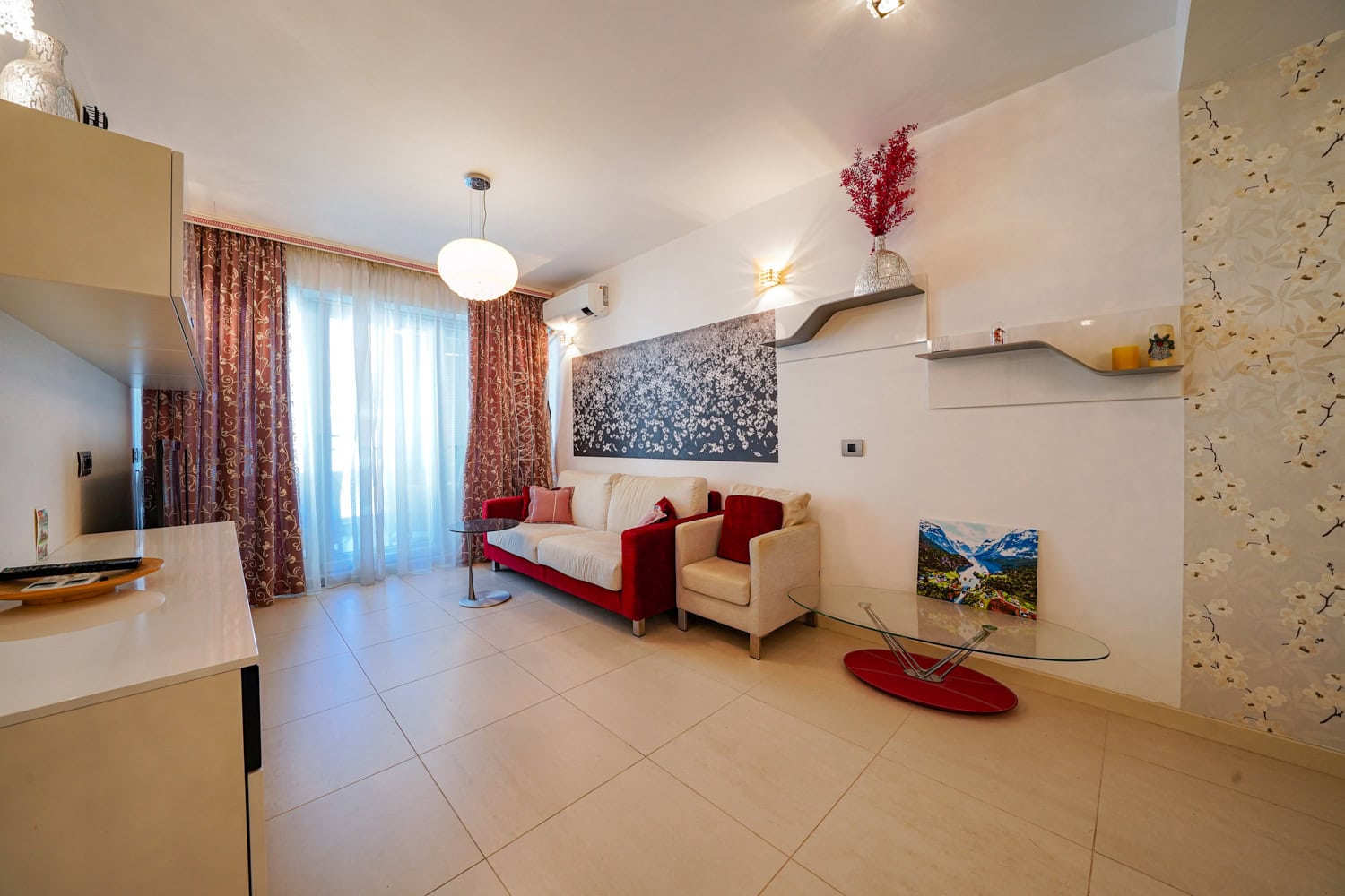 Cozy living room with soft furniture and access to the balcony in an apartment in Budva, Montenegro. Modern interior with decor.