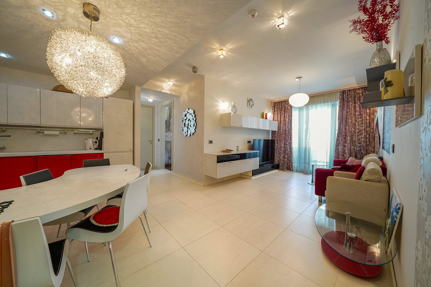 Modern living room with kitchen in an apartment in Budva, Montenegro: bright interior, dining area, and soft seating.